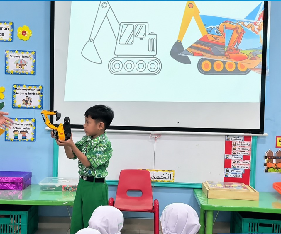 Guest Teacher TK Islam Al Azhar 17 Bintaro, murid kelompok A4 memegang miniatur excavator dalam kegiatan Introduction to Excavator