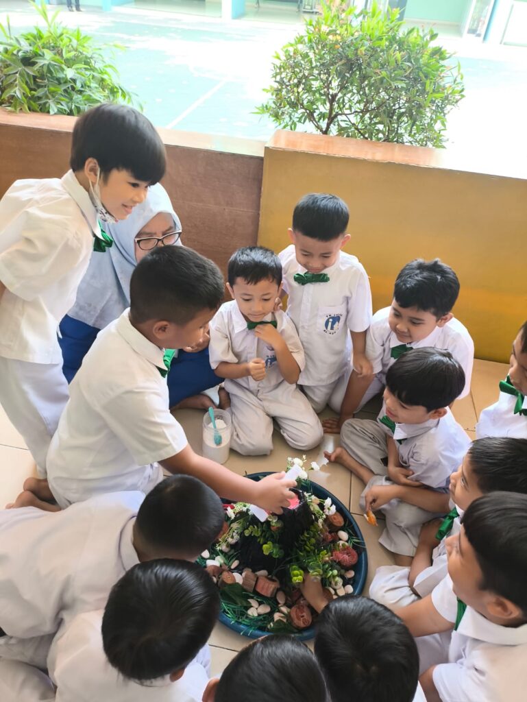 Murid TK Islam Al Azhar 17 Bintaro antusias mengamati miniatur gunung berapi dalam kegiatan pembelajaran sains