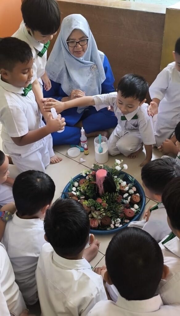 Murid TK Islam Al Azhar 17 Bintaro antusias mengamati miniatur gunung berapi menyemburkan cairan seperti magma